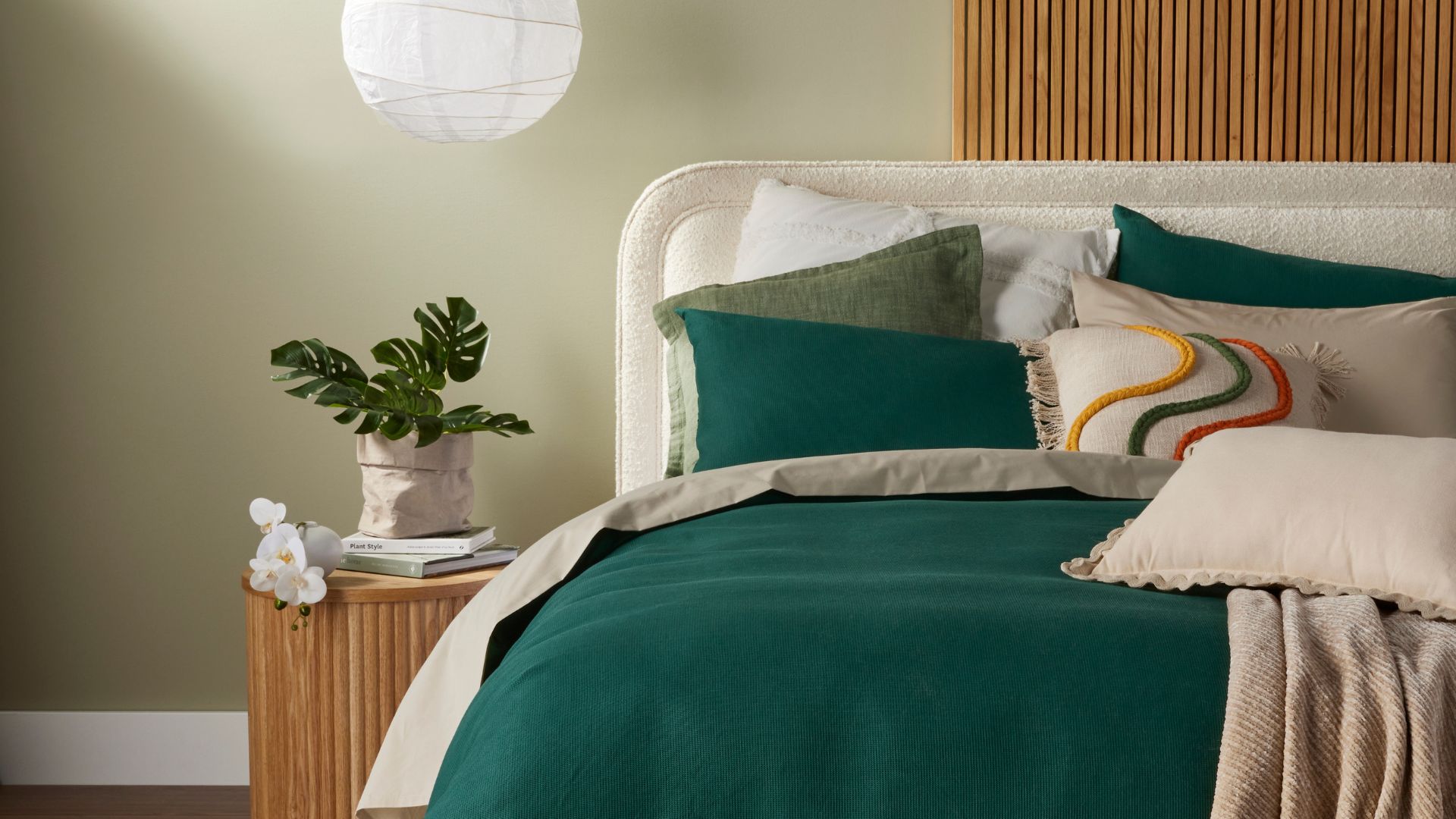 Teal bed linen and green cushions styling